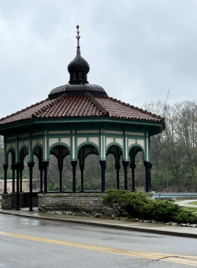  "This image shows a peaceful landscape view of Eden Park in Cincinnati, with lush greenery, walking paths, and the serene lakes reflecting the clear sky."

