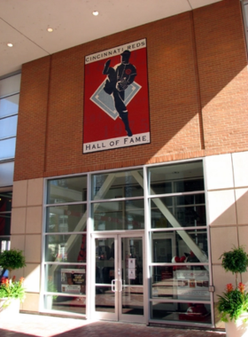 "This image shows a display at the Cincinnati Reds Hall of Fame, showcasing historic baseball memorabilia, including jerseys and equipment from iconic Reds players."