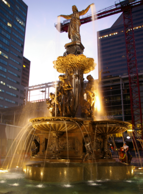  "This image shows a live music event taking place at Fountain Square, with a large crowd enjoying the performance, surrounded by restaurants and the iconic fountain in the center."

