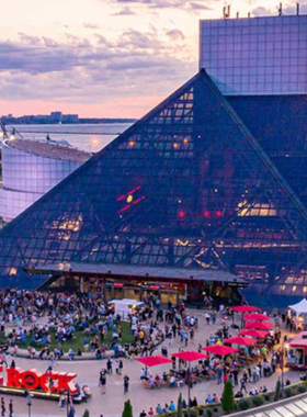  This image shows the interior of the Rock & Roll Hall of Fame in Cleveland, featuring a rich display of musical artifacts like guitars and stage costumes from legendary rock artists.

