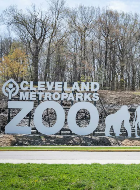  This image shows visitors observing exotic animals at the Cleveland Metroparks Zoo, including giraffes and elephants in their spacious, naturalistic enclosures.