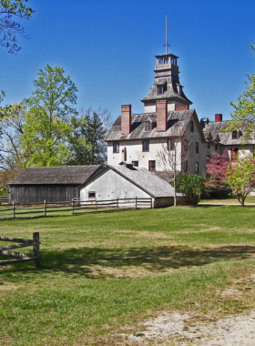 This image shows the preserved mansion in Batsto Village, surrounded by lush greenery, reflecting its role as a historic iron and glassmaking hub.