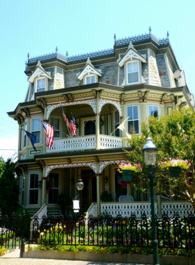 This image shows a beautifully preserved Victorian home in Cape May, surrounded by blooming flowers, reflecting its timeless charm.