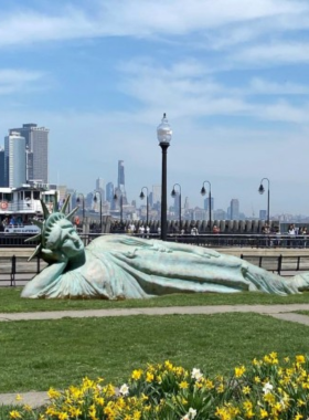  This image shows Liberty State Park with a scenic view of the waterfront, showcasing the Statue of Liberty and Ellis Island in the distance.