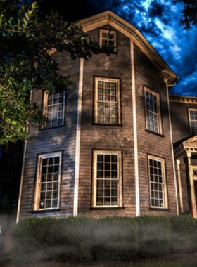 This image shows a tour guide narrating eerie stories in front of a historic building during a Ghost and Ghouls tour, creating a thrilling experience.