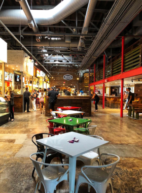 This image shows a vibrant indoor food hall with people enjoying meals at Morgan Street Food Hall, featuring a variety of food options and lively ambiance.