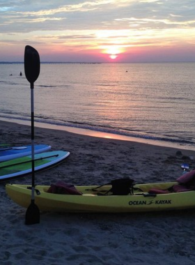 This image shows that a sunset dolphin kayak tour in Virginia Beach allows visitors to paddle along the calm waters while observing dolphins in their natural habitat, offering a peaceful and memorable outdoor adventure.