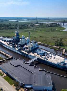 This image shows visitors exploring the deck of the Battleship North Carolina, a historic World War II battleship, offering a unique museum experience and a view of Wilmington’s waterfront.