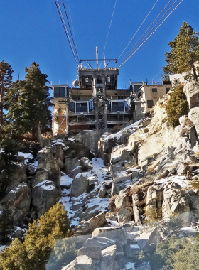 This image shows the Palm Springs Aerial Tramway with its iconic cable cars gliding over the Coachella Valley, offering breathtaking views of the desert landscape below.