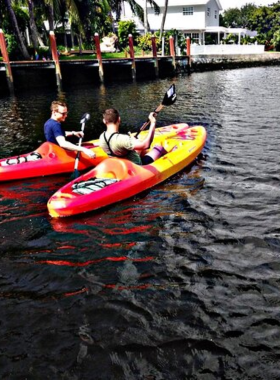  This image shows a serene boat tour along Fort Lauderdale's winding canals, offering scenic views of beautiful waterfront homes, yachts, and lush greenery, highlighting the city’s Venetian charm.