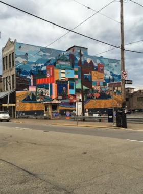  "This image shows the lively Strip District in Pittsburgh, filled with open-air markets, colorful food stalls, and busy streets. It captures the area’s bustling activity, with people exploring different stalls selling local produce, unique foods, and souvenirs."