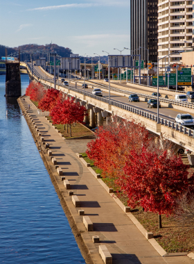 "This image shows a picturesque part of the Three Rivers Heritage Trail, with a paved path along the river and the city skyline in the distance. The trail is popular with walkers and cyclists, providing a scenic route through Pittsburgh’s waterfront."
