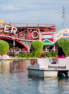 "This image shows a classic roller coaster at Kennywood Amusement Park, with riders enjoying the thrilling twists and turns. The park’s fun atmosphere is visible through colorful rides and joyful visitors, making it a beloved spot for all ages."