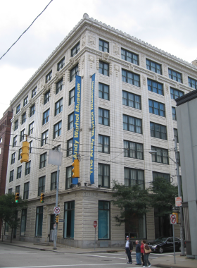 "This image shows the entrance to the Andy Warhol Museum in Pittsburgh, with large, colorful signage celebrating the famous pop artist. Visitors entering can experience Warhol’s legacy, with the building’s unique exterior hinting at the vibrant art inside."