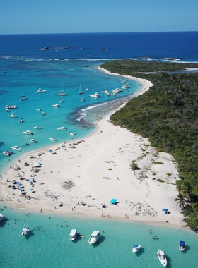 This image shows the crystal-clear waters surrounding Icacos Island, highlighting a snorkeling paradise. The sandy beach and turquoise sea stretch out to the horizon, offering a perfect spot for relaxation and exploring vibrant marine life beneath the surface.