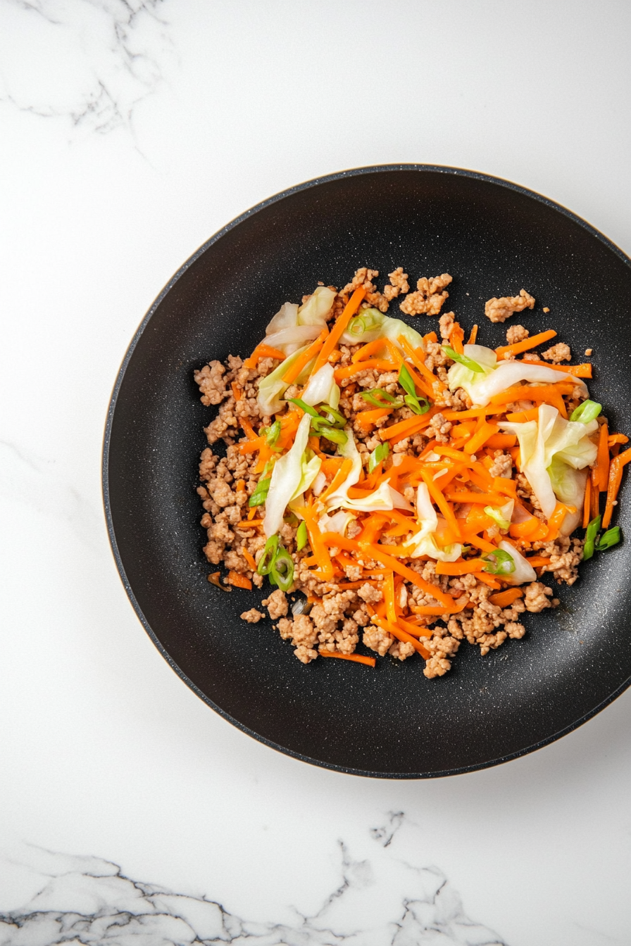 Add cabbage, carrots, and green onion; stir-fry for 2–3 minutes. Let it cool.