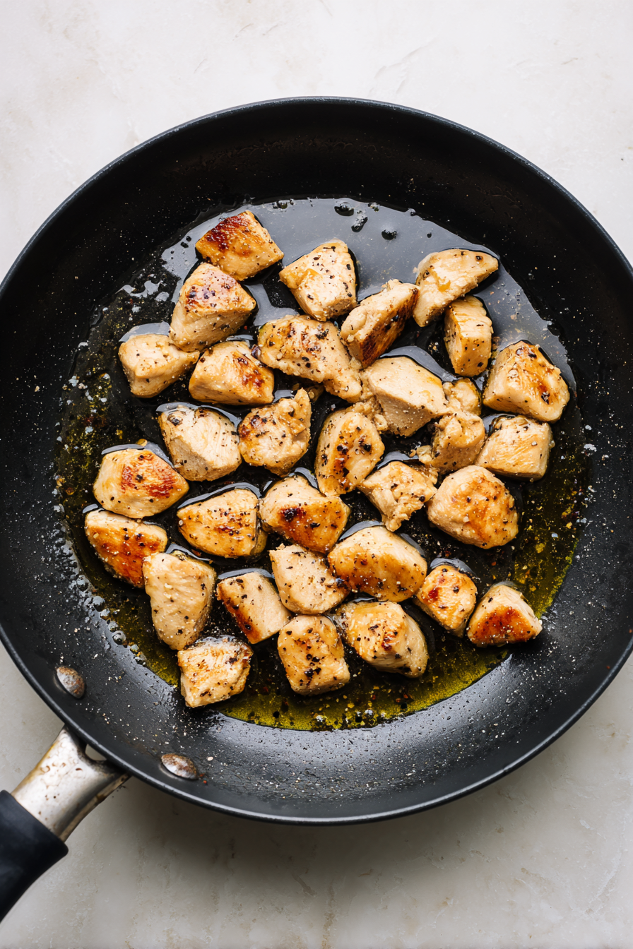 Heat oil in a skillet, sauté chicken with salt and pepper until cooked through.
