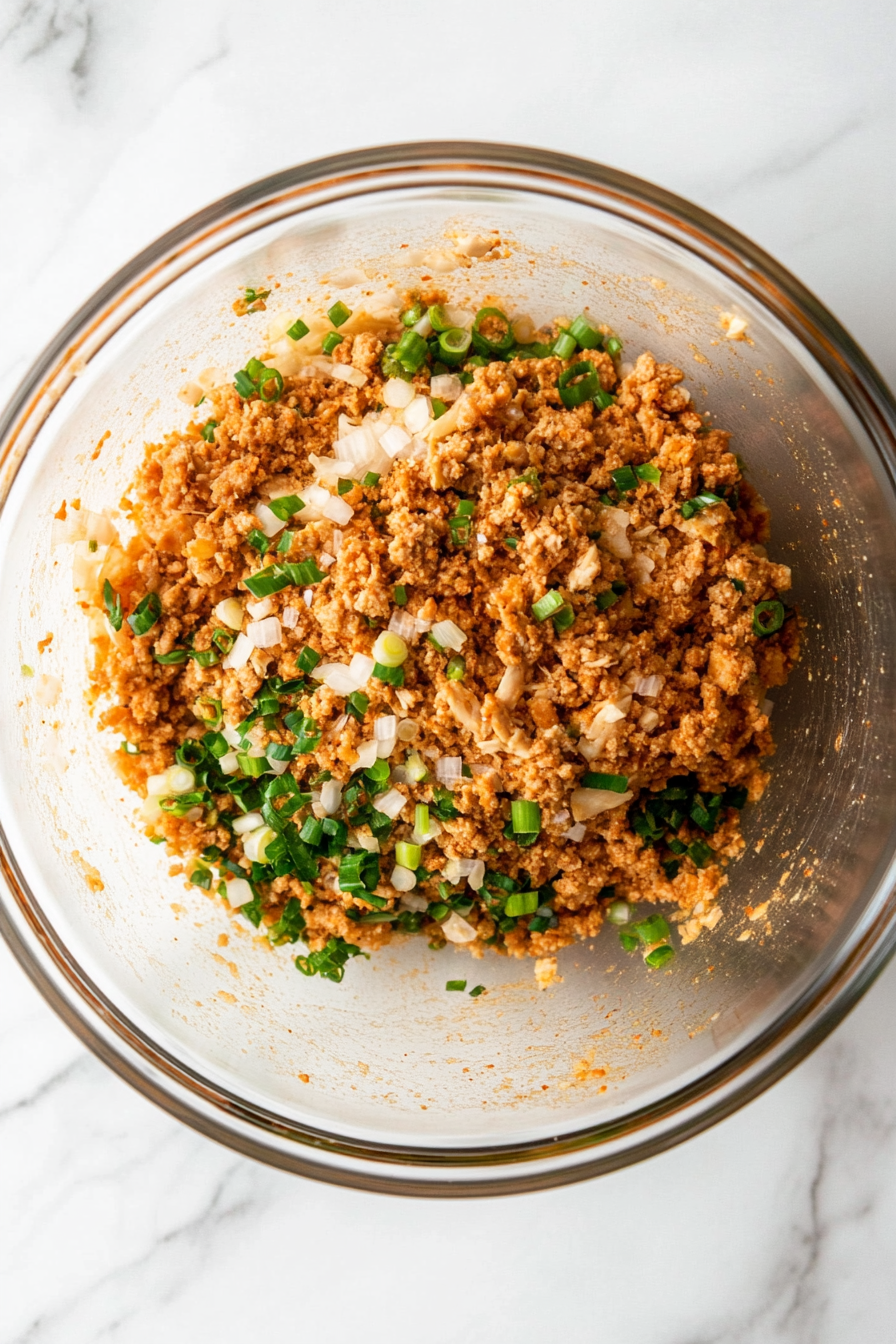 In a bowl, combine ground chicken, minced garlic, grated ginger, black pepper, paprika, salt, green onion, and soy sauce. Mix well.
