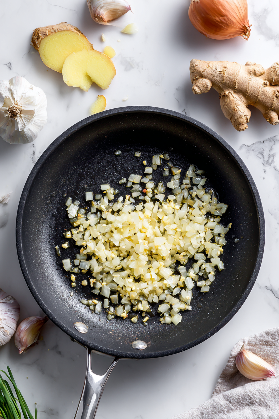 Heat olive oil in a deep pan and sauté chopped onion, garlic, and ginger until golden.