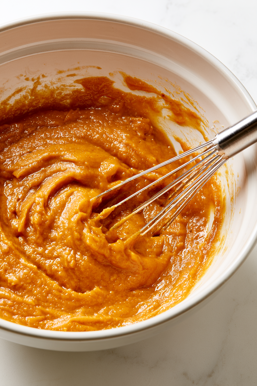 Stir-in-the-pumpkin-puree-and-a-large-egg-mixing-until-the-mixture-is-thick-smooth-and-fragrant