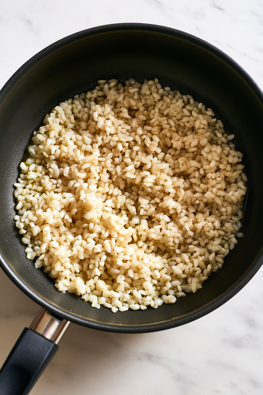 Add the arborio rice to the saucepan and stir well to coat each grain with the oil and aromatics