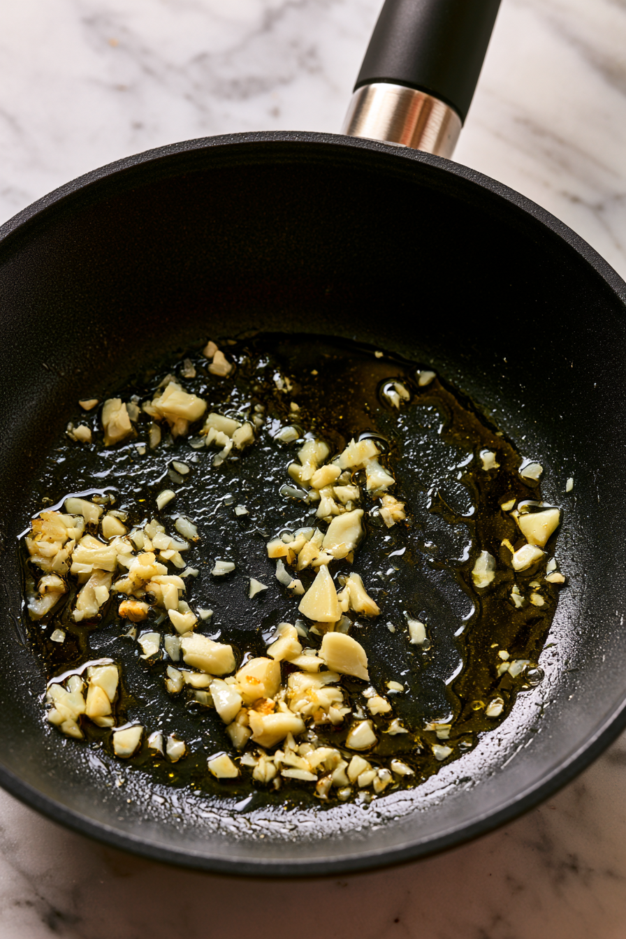 While the tomatoes are roasting, heat a small amount of olive oil in a skillet over medium heat. Add the minced garlic and cook until fragrant, about 1 minute