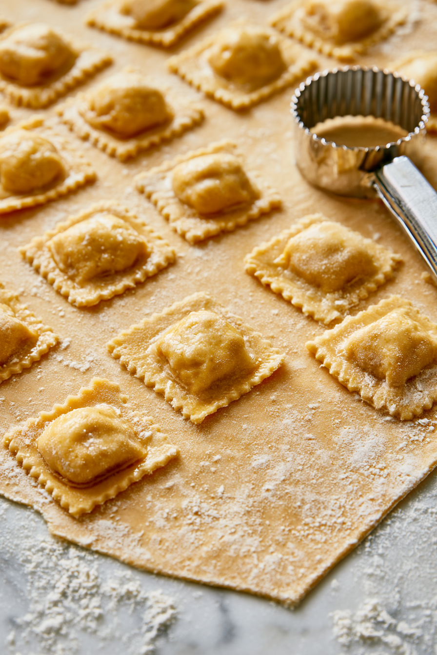 Gently press around each mound of filling to remove air, then cut between the dollops with a sharp knife or ravioli cutter to form individual squares