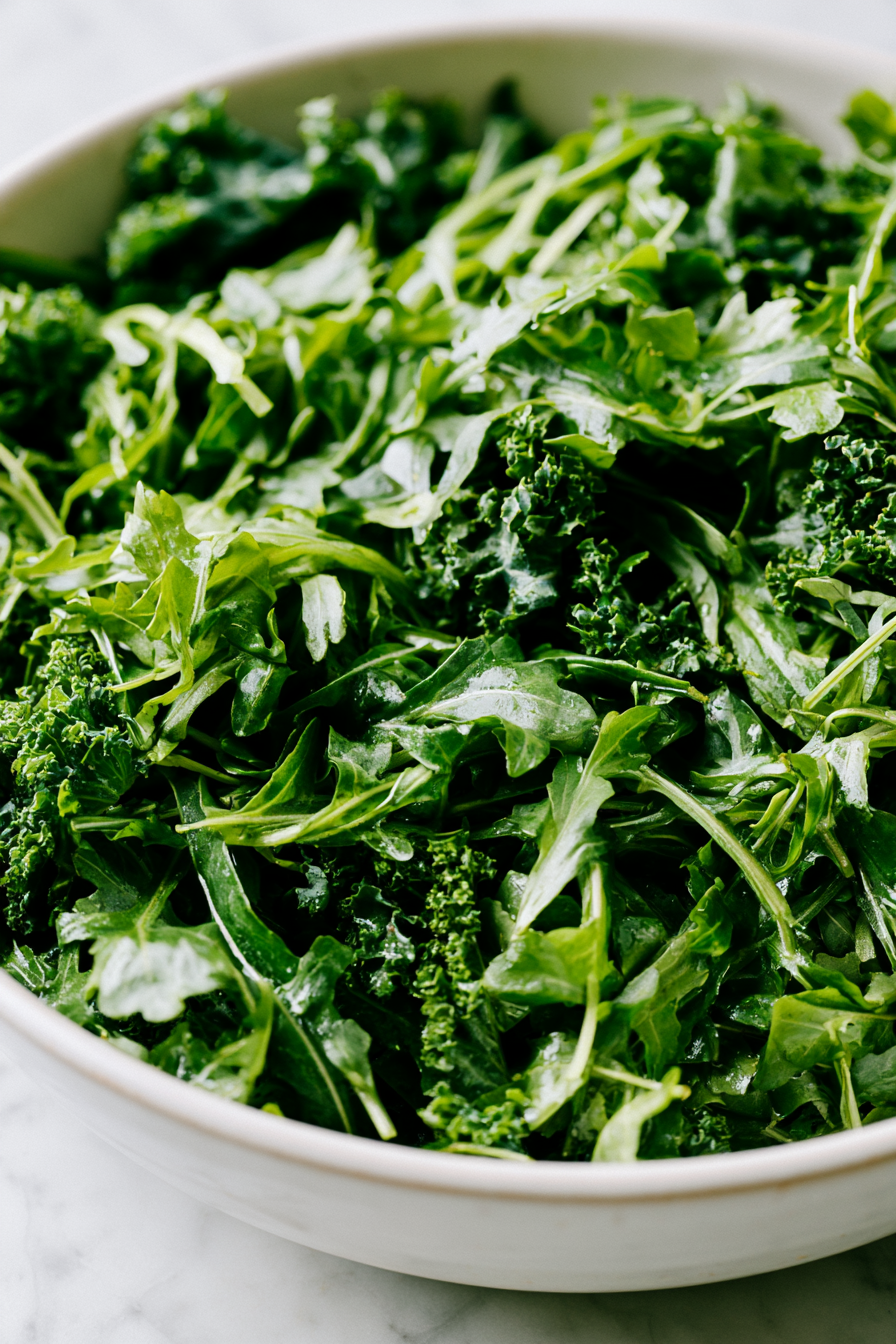 While the pumpkin roasts, prepare your salad base by placing mixed greens in a large mixing bowl