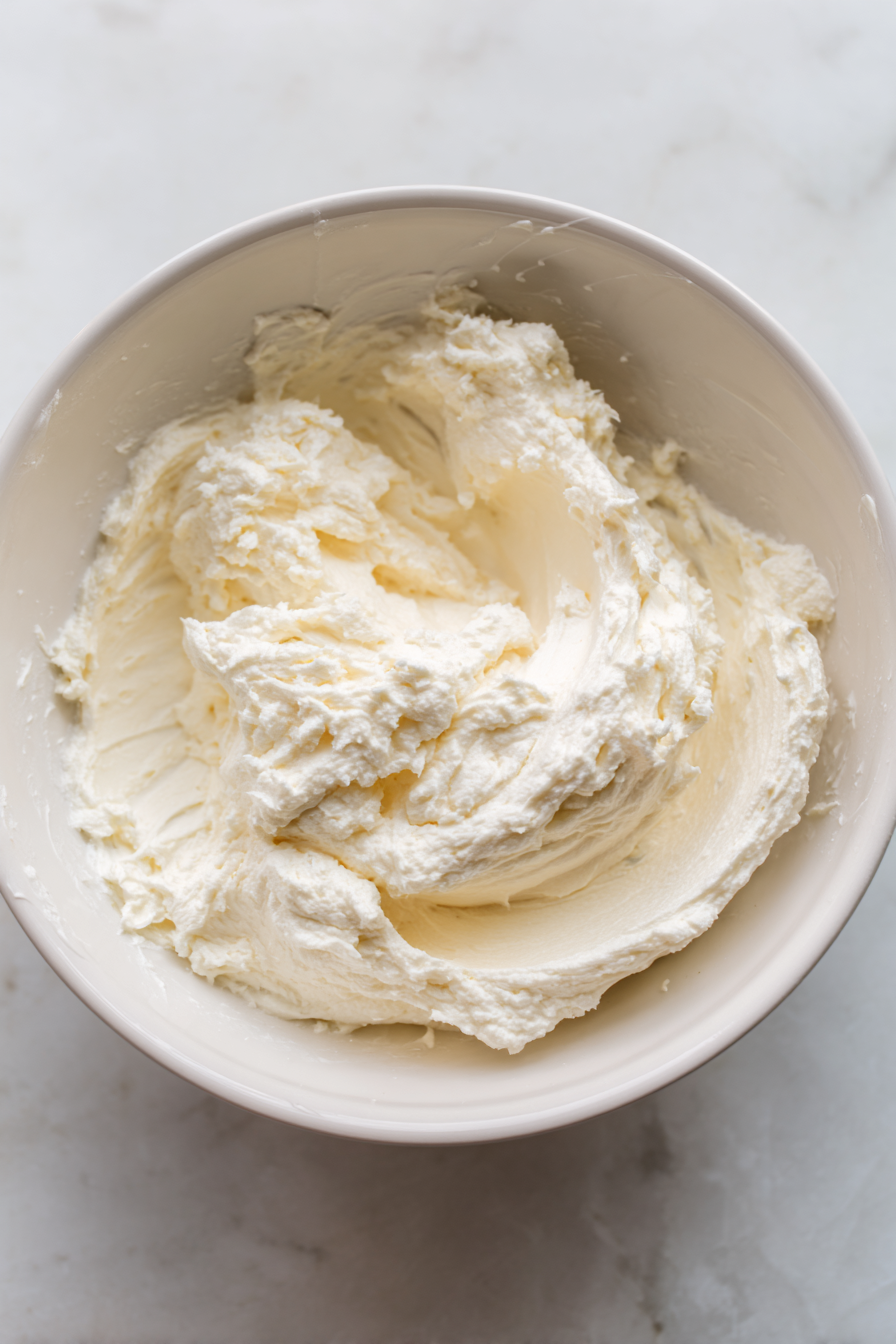 In a mixing bowl, combine softened cream cheese, sour cream, and mayonnaise