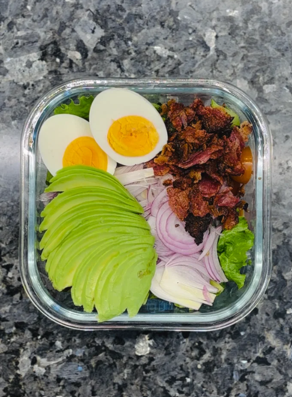 Peel and slice the avocado, then arrange the slices around the salad.