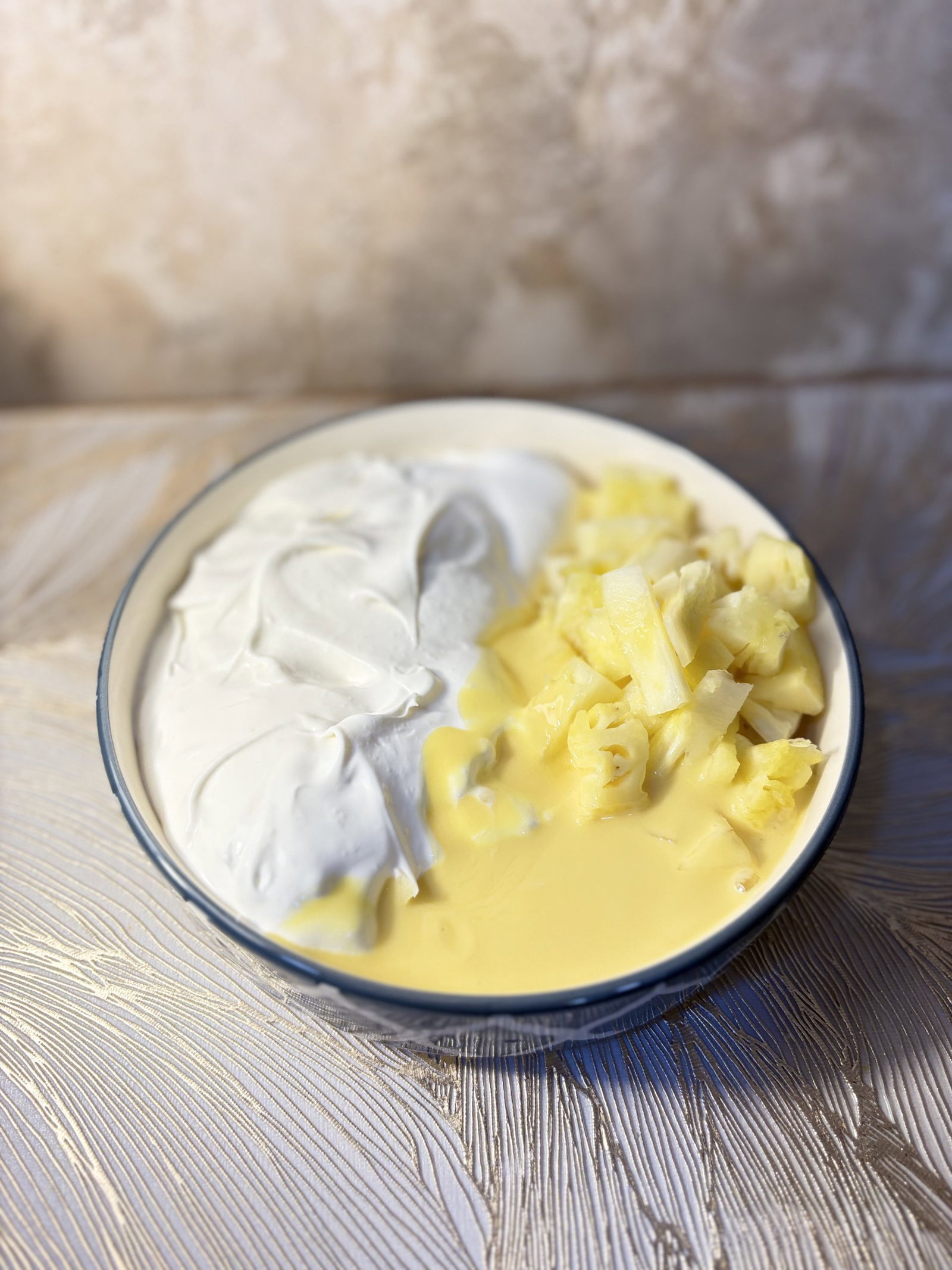 In a mixing bowl, combine the dry pudding mix, Cool Whip, and crushed pineapple until everything is well mixed.