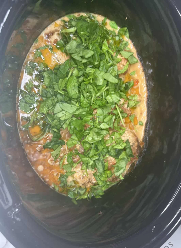 Once the chicken is cooked, add chopped spinach to the crockpot