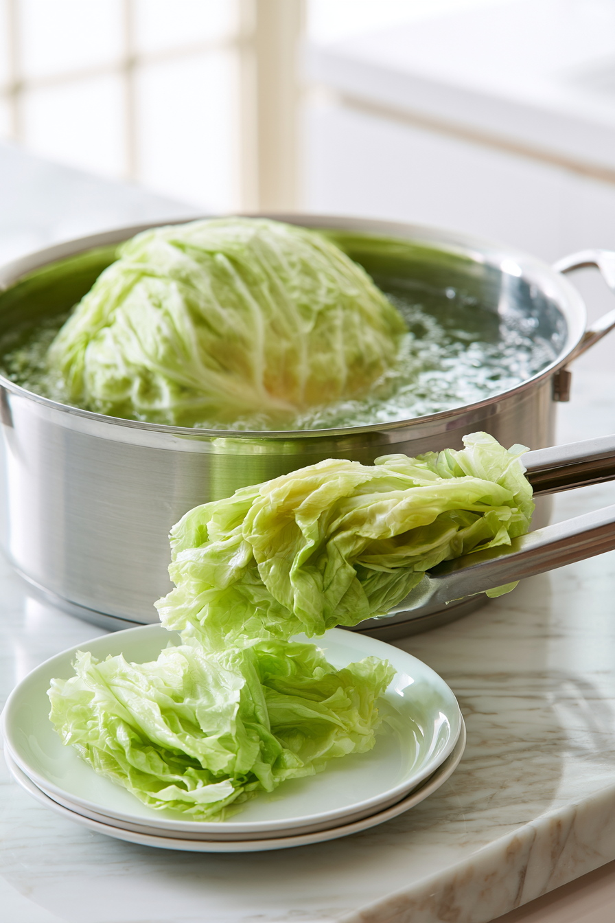 Bring a large pot of salted water to a boil. Carefully remove the core from the cabbage and lower the whole head into the boiling water