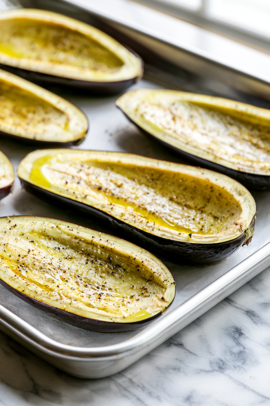 Brush the eggplant halves with olive oil and season with salt and black pepper