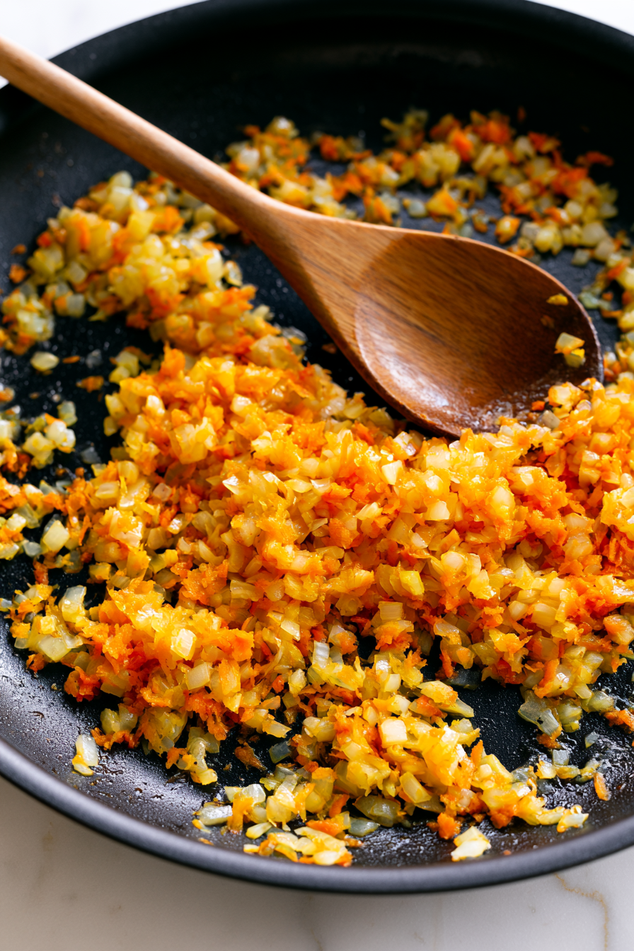 Heat the olive oil in a large skillet over medium heat. Add the onion and carrot and cook for about 5 minutes until softened
