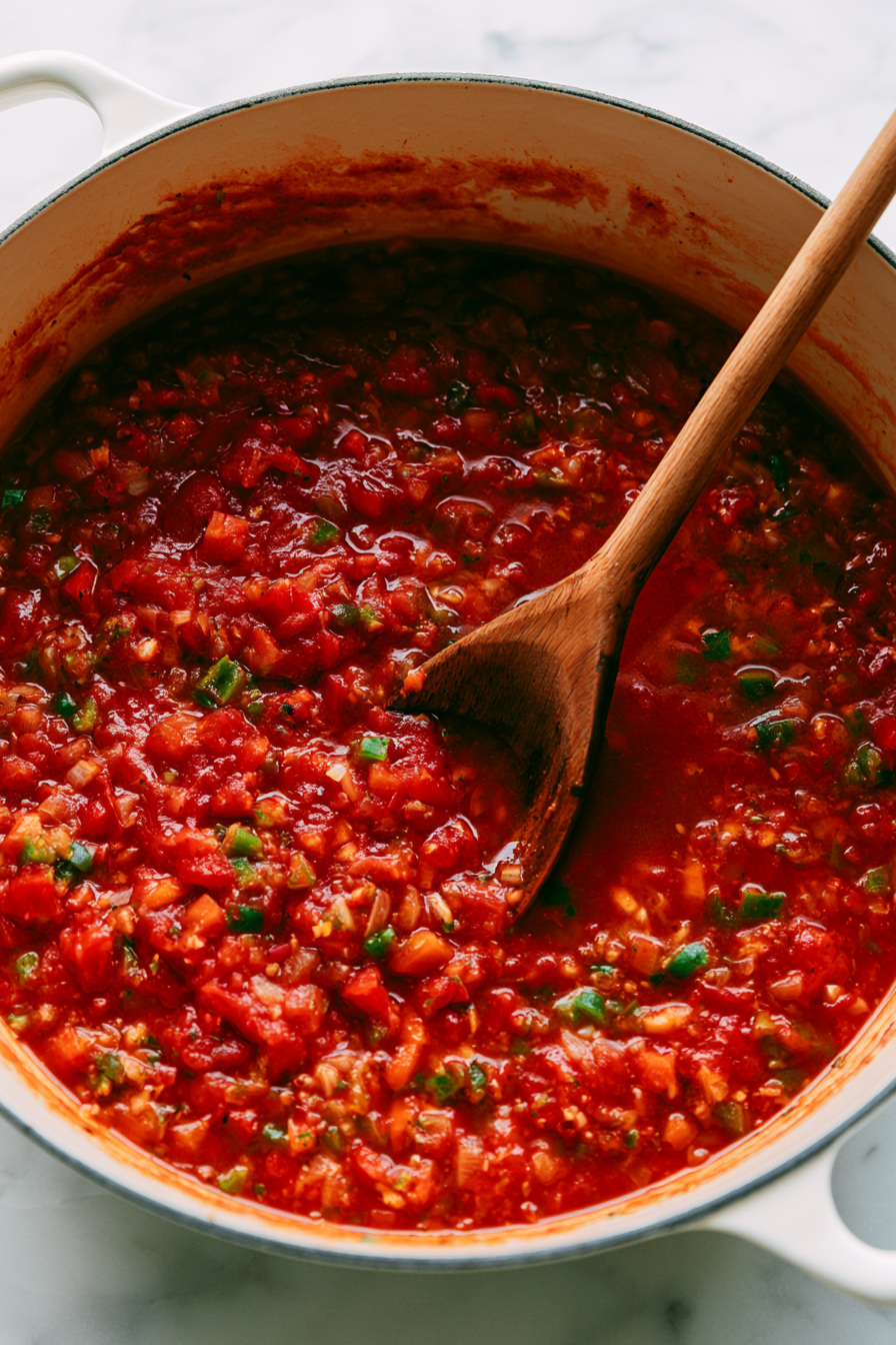 Pour in the crushed tomatoes, fire-roasted tomatoes, and vegetable broth