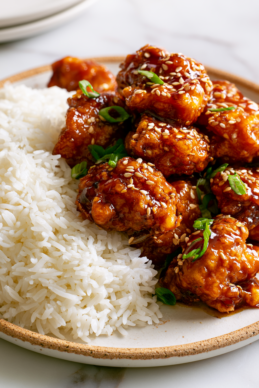 Serve immediately over steamed jasmine rice and garnish with sliced green onions and toasted sesame seeds