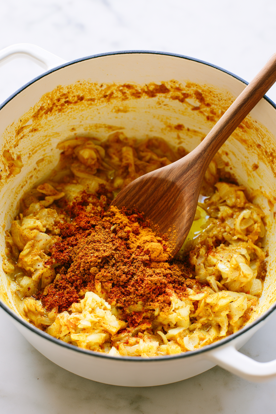 Sprinkle in the curry powder, ground cumin, coriander, turmeric, smoked paprika, and cayenne.