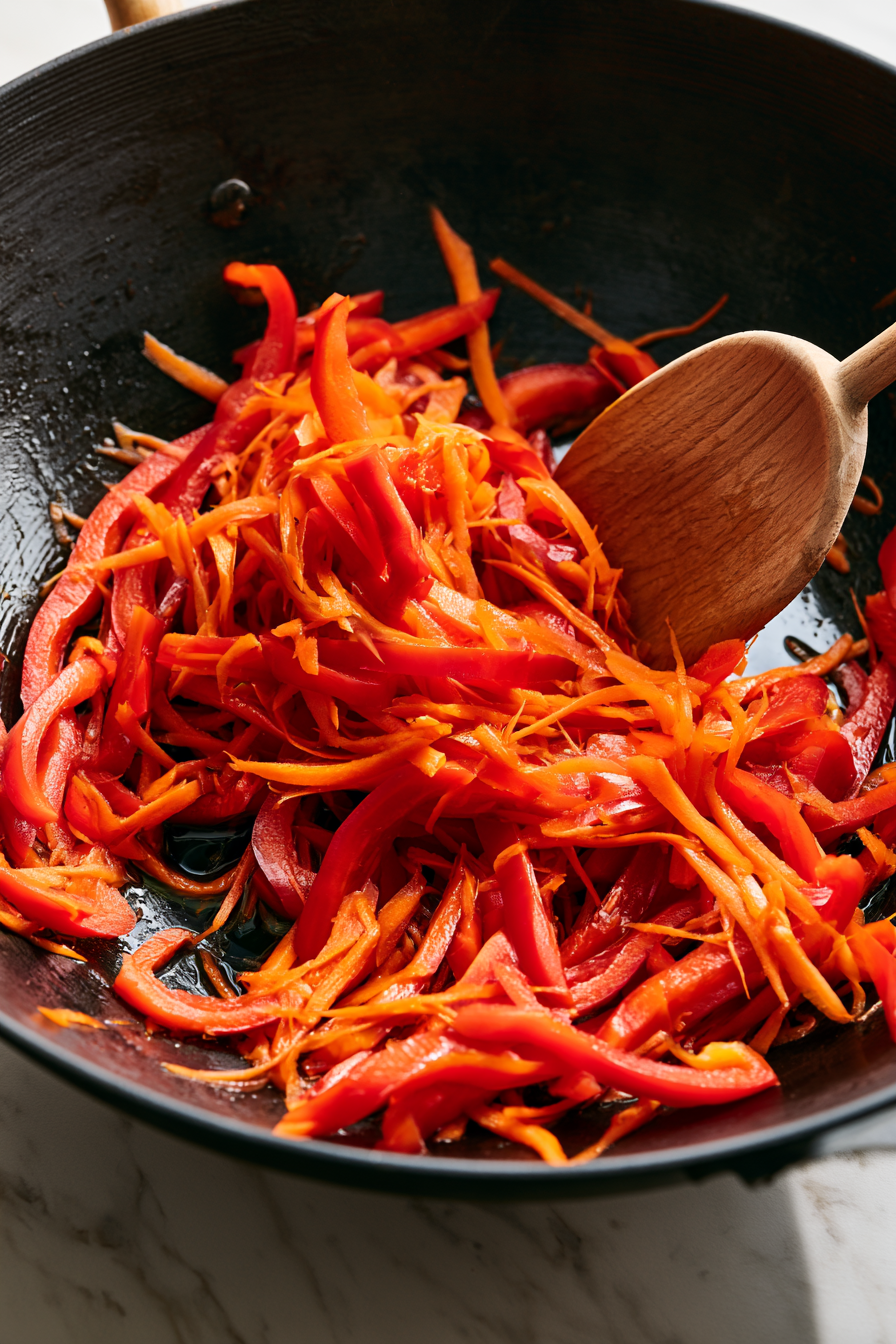 Add the bell pepper and carrots to the hot pan and stir-fry for 2–3 minutes until slightly tender while keeping some crunch