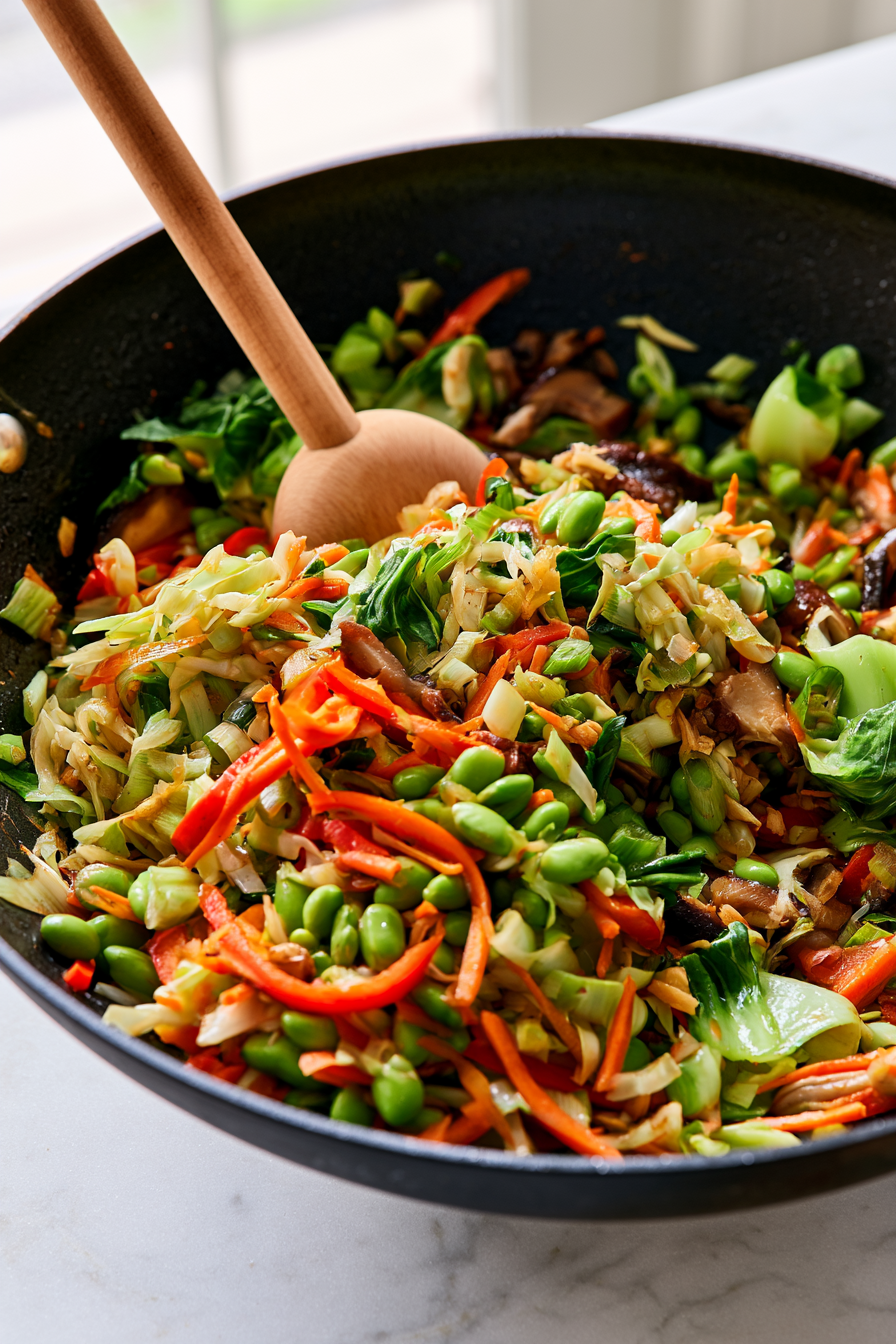 Add the bok choy leaves and edamame, then toss everything together for another minute