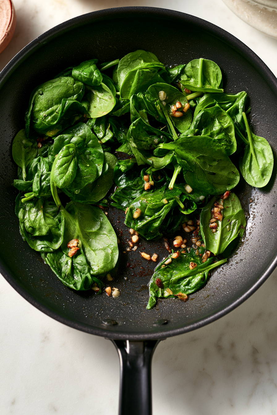 Add the minced garlic to the skillet and cook for about 30 seconds. Add the spinach and sauté until just wilted