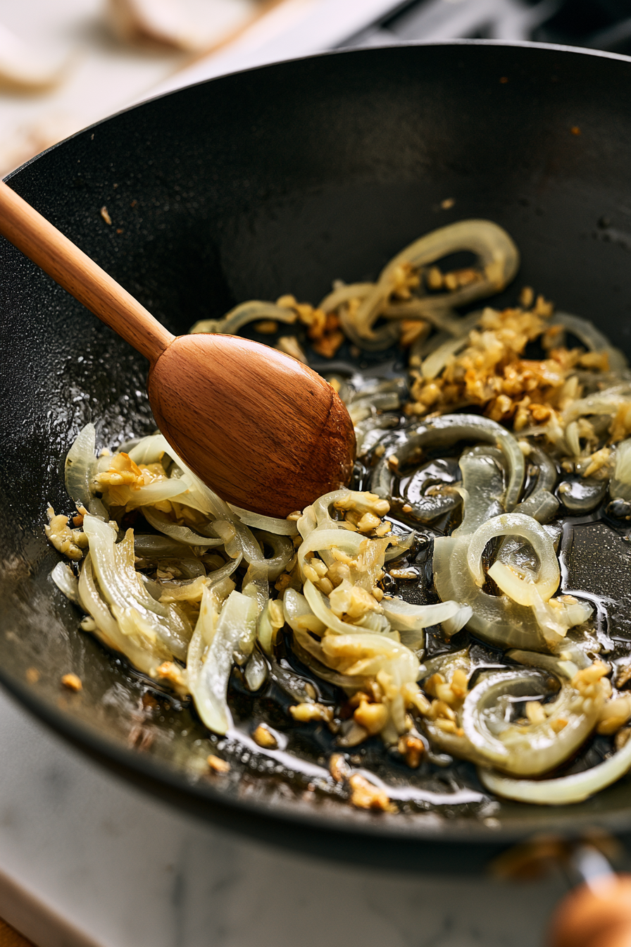 Add the remaining tablespoon of oil to the pan. Add the onion and garlic and stir-fry for 1–2 minutes until fragrant and slightly softened
