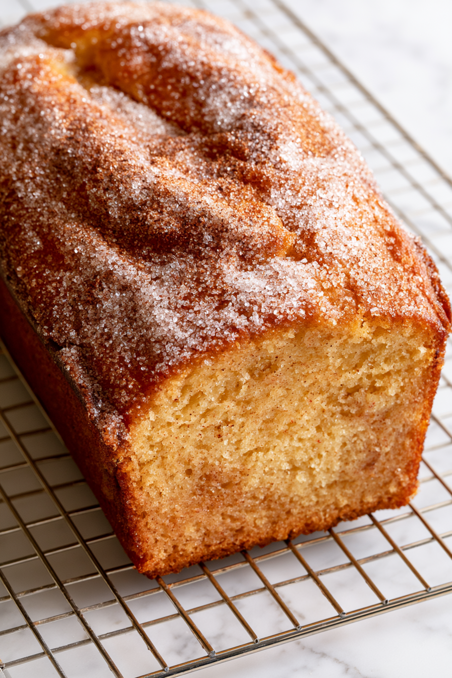Brush the warm loaf all over with melted butter. Combine the granulated sugar and cinnamon, then press the mixture generously over the top and sides of the loaf