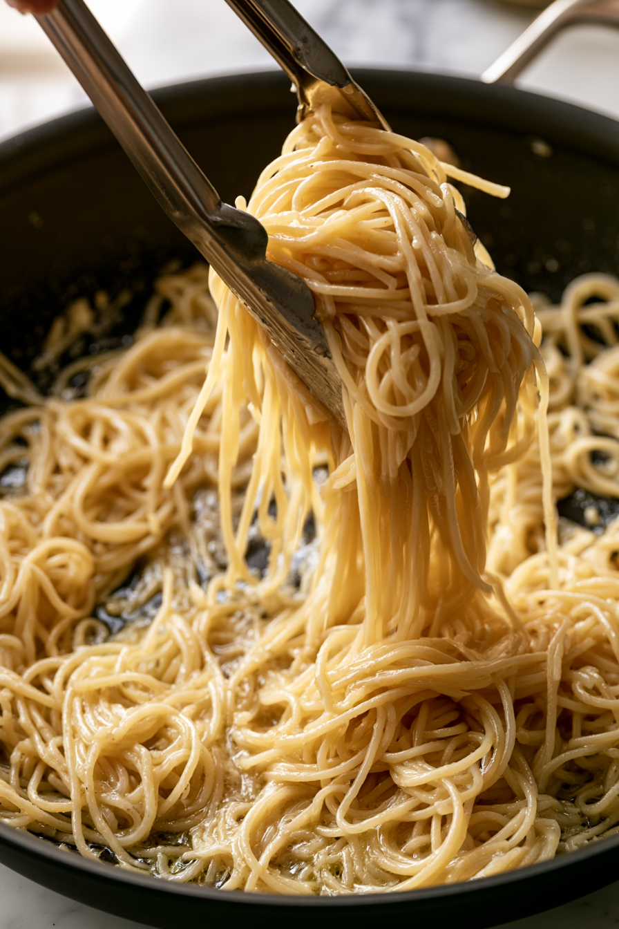 Continue tossing the pasta for 1–2 minutes, adding more pasta water as needed until the sauce lightly clings to every strand